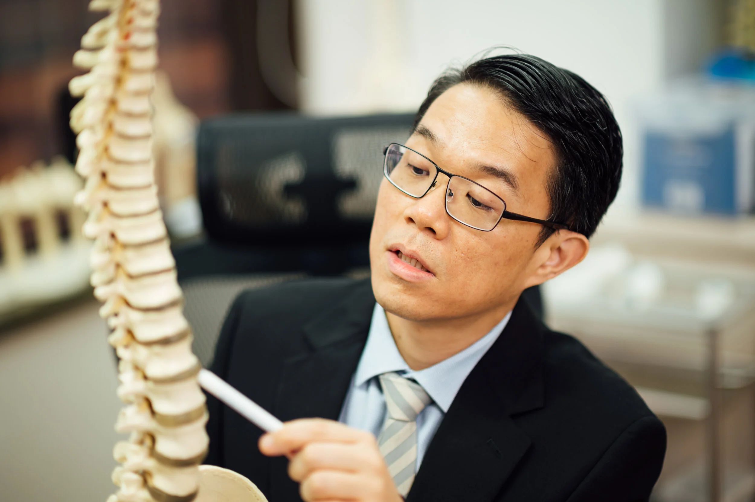杜博文医生使用脊柱模型向病人讲解脊椎病情。